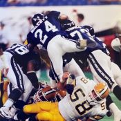 A group of professional football players in a tackle.