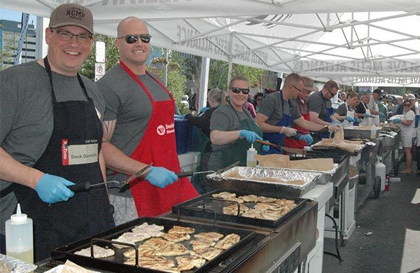 Volunteers frying fish to serve to public