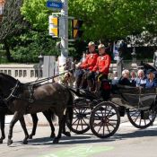 Two Mounties ride coach as King Charles rides in an open carriage.