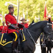 Mountie on a black horse holds a long sword.