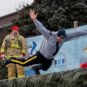 An RCMP officer does a belly flop into a large pool