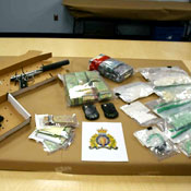 Guns, cash, cellphones and drugs (cocaine and fentanyl) seized by Yukon RCMP.