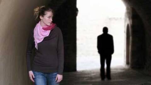 Person walking with a black silhouette of another person behind them
